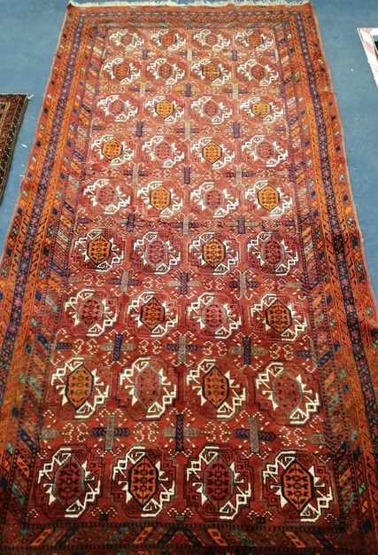 A Bokhara red ground carpet 260 x125cm
